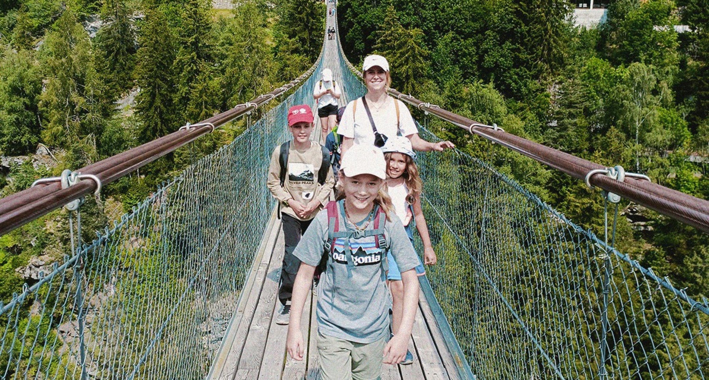 Schülerinnen und Schüler gehen über eine Hängebrücke.