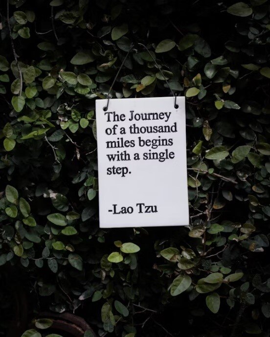 Ein Blatt mit dem Spruch: The Journey of a thousand miles begins with a single step. - Lao Tzu.