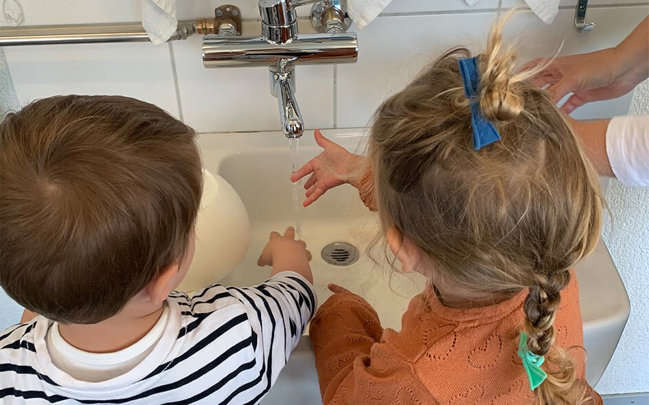 Zwei Kinder waschen sich die Hände.