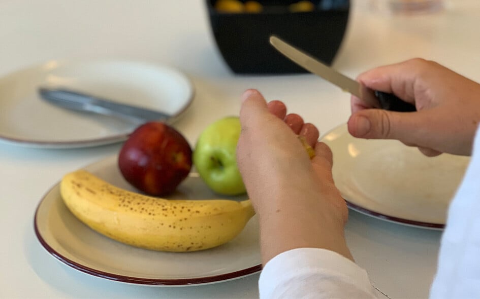 Ein Teller mit einer Banane und zwei Äpfeln.