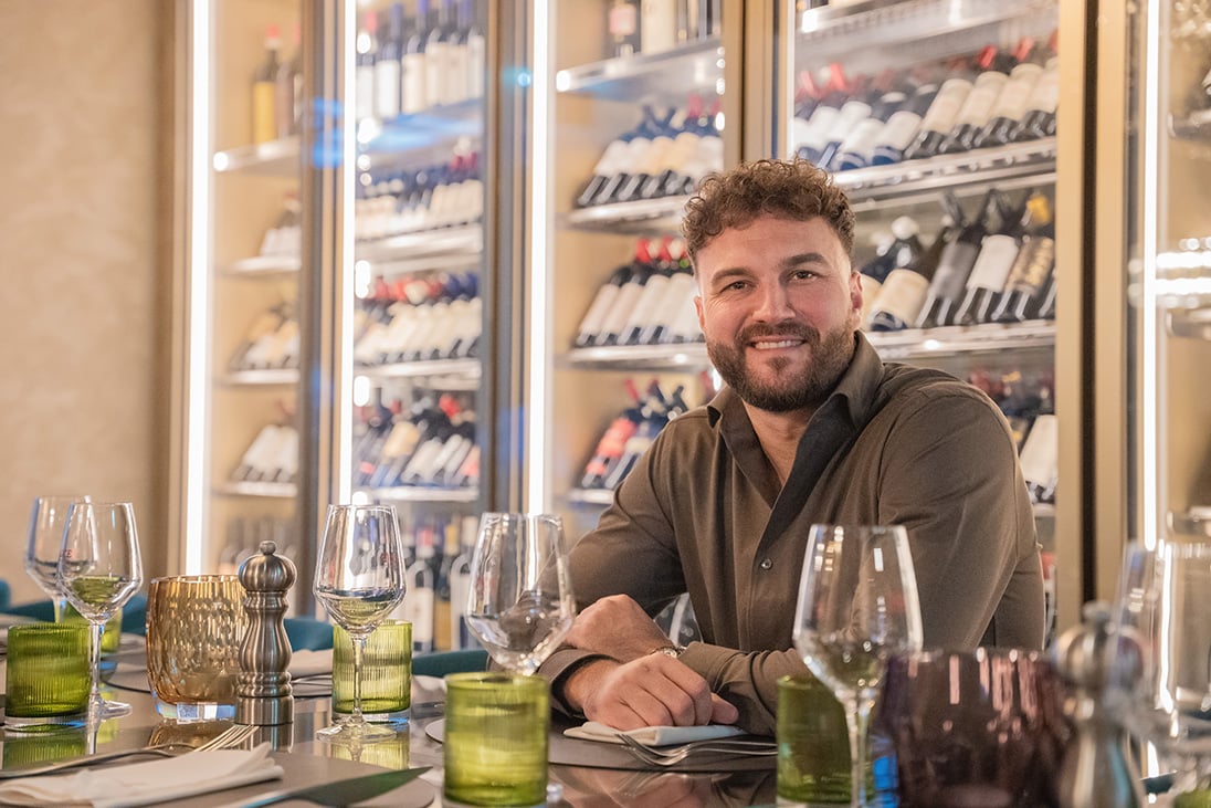 Nicola Nilovic sitzt an einem schön gedeckten Tisch.