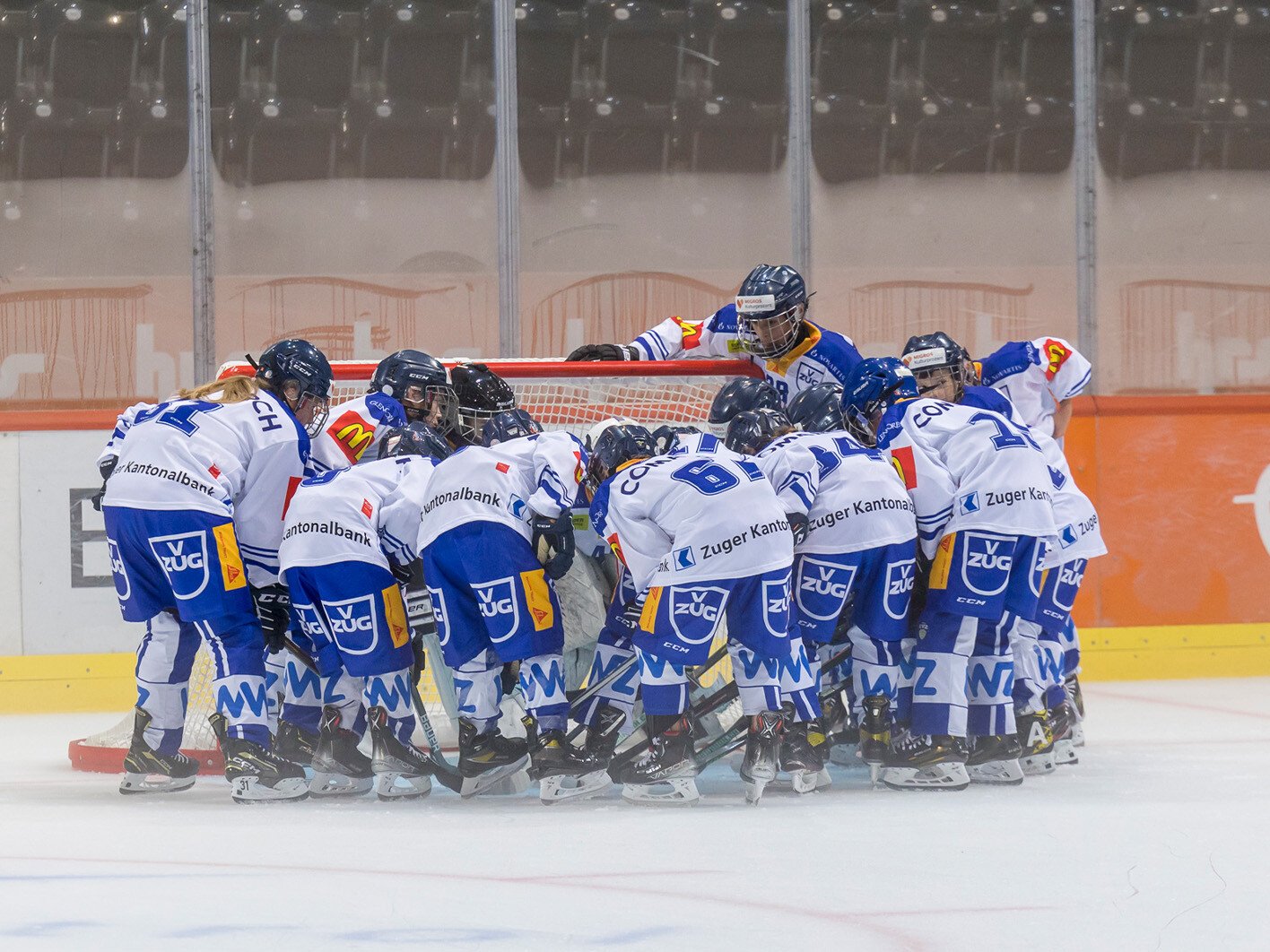 Die HC Dragon Thun Eishockeyspieler versammeln sich vor dem Tor.