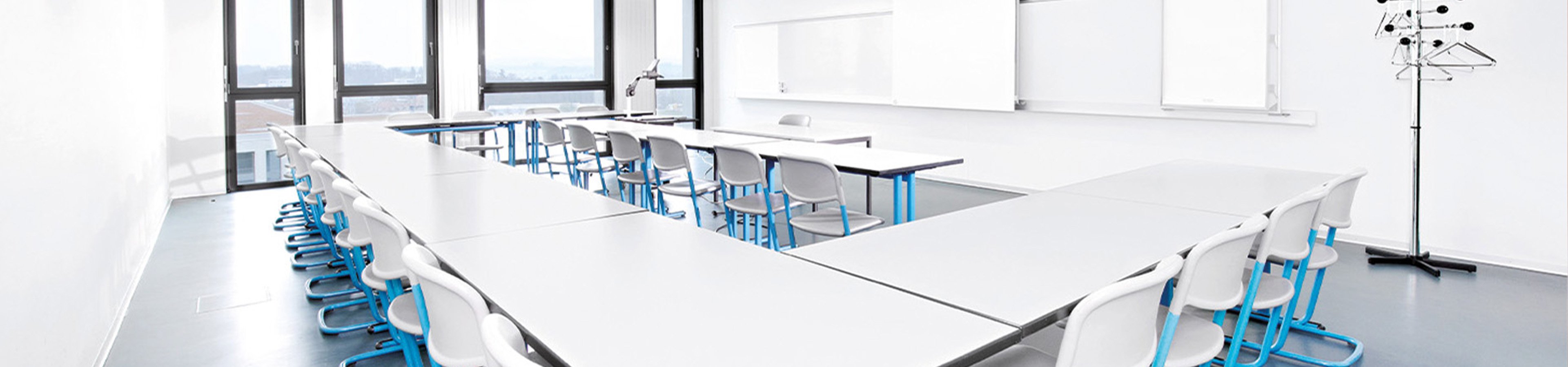 Ein Schulzimmer mit Tischen und Stühlen ohne Lernende.