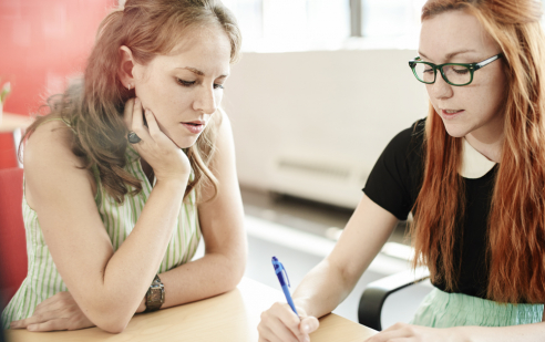 PraktiKa Praktikumsstellen-Management in der Feusi in Bern. Zwei junge Frauen unterhalten sich.