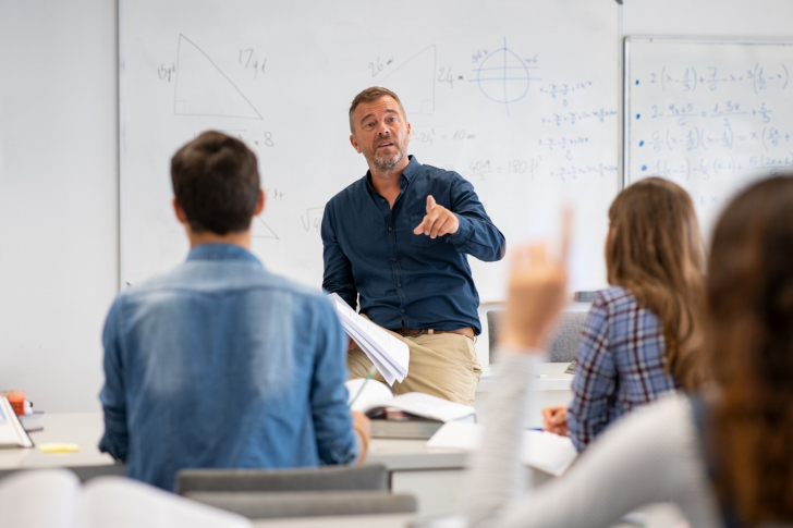 Lehrer und Schüler in einem Klassenzimmer.