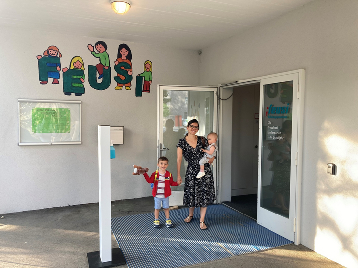 Eine Frau mit zwei Kindern steht vor der Eingangstüre der Feusi in Muri-Gümligen.