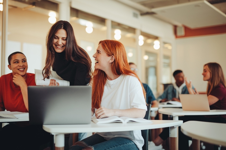 Verschiedene Personen in einem Büro arbeiten mit Laptops.