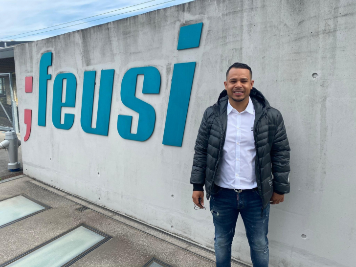 Kelvin Tröhler vor dem Feusi Logo