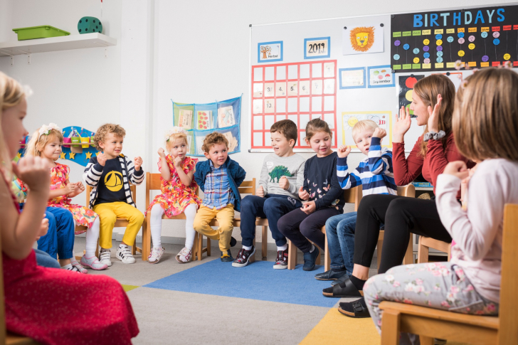 Mehrere Kinder sitzen in einem Kreis