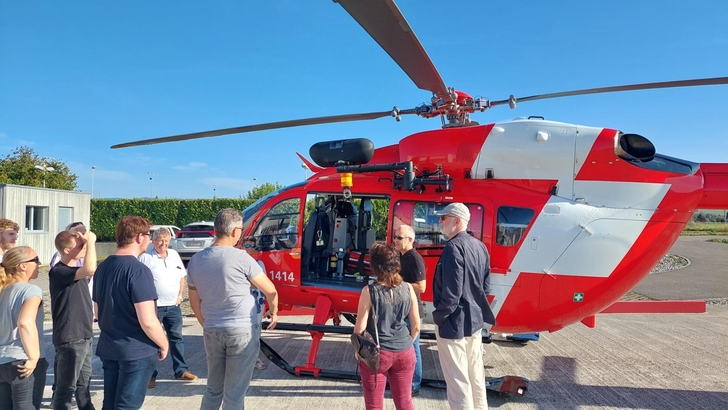 Menschen stehen vor einem Helikopter.