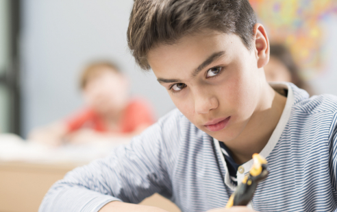 Ein Junge an der Feusi Primarstufe in Muri-Gümligen schreibt.