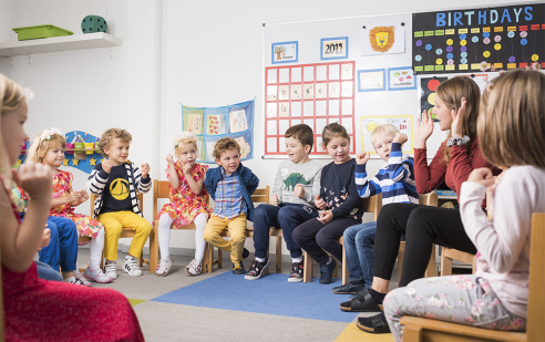 Kinder im Feusi Kindergarten in Muri.Gümligen sitzen im Kreis und machen Gruppenspiele.