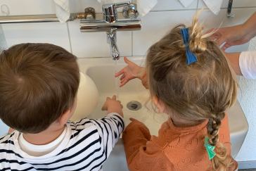 Zwei Kinder waschen sich die Hände.