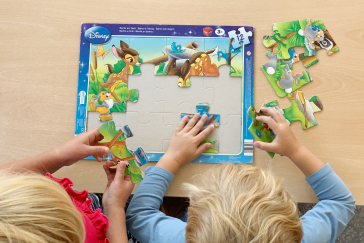 Two children playing a puzzle.