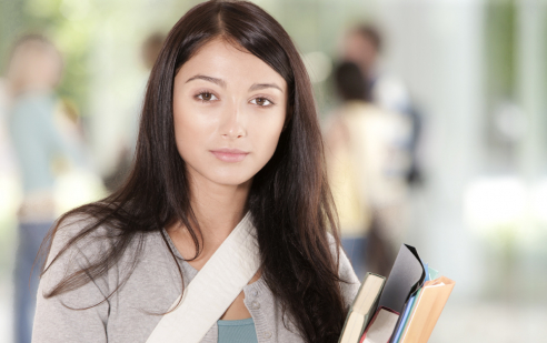 Berufsmaturität für Leistungssportler/-innen in Bern. Eine junge Frau hält Bücher im Arm.